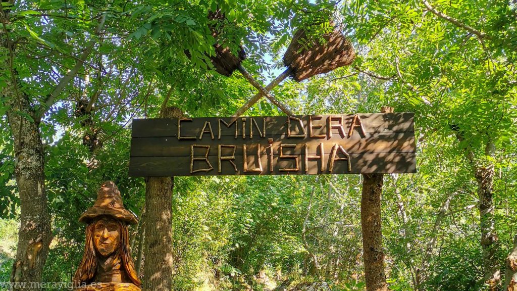 Entrada al Camino de la Bruja, en Tredós (cartel y escultura de una bruja)